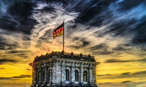 Ein historisches Gebäude mit deutscher Flagge auf dem Dach – ein Symbol für die sprachliche und kulturelle Verbindung zwischen Deutschland und Dänemark. Professionelle Deutsch Dänisch Übersetzer bauen Brücken zwischen beiden Sprachen mit Präzision und Feingefühl.